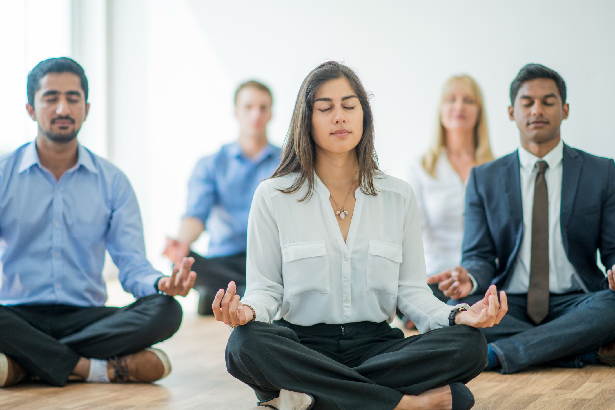 A-multi-ethnic-group-of-young-business-men-and-women-meditating-fast-paced-environment