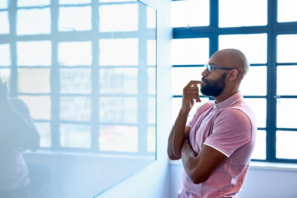 African-male-staring-at-whiteboard-what-causes-lack-of-focus-at-work