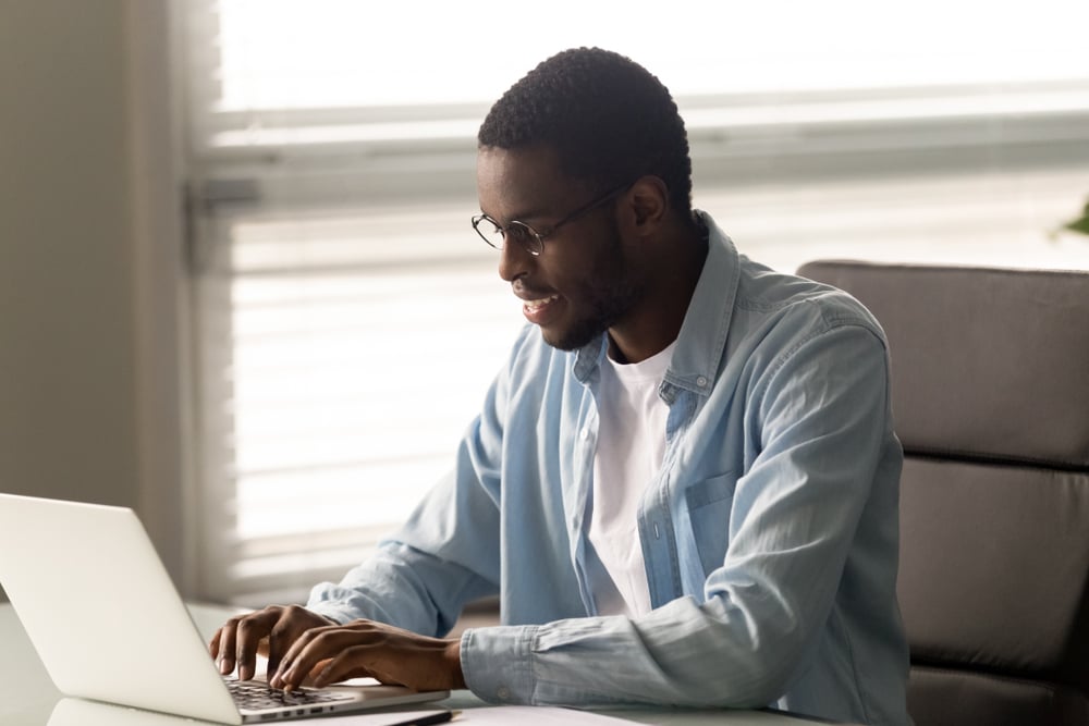 Afroamerican-man-writing-letter-in-his-lapop-personal-reason-leave