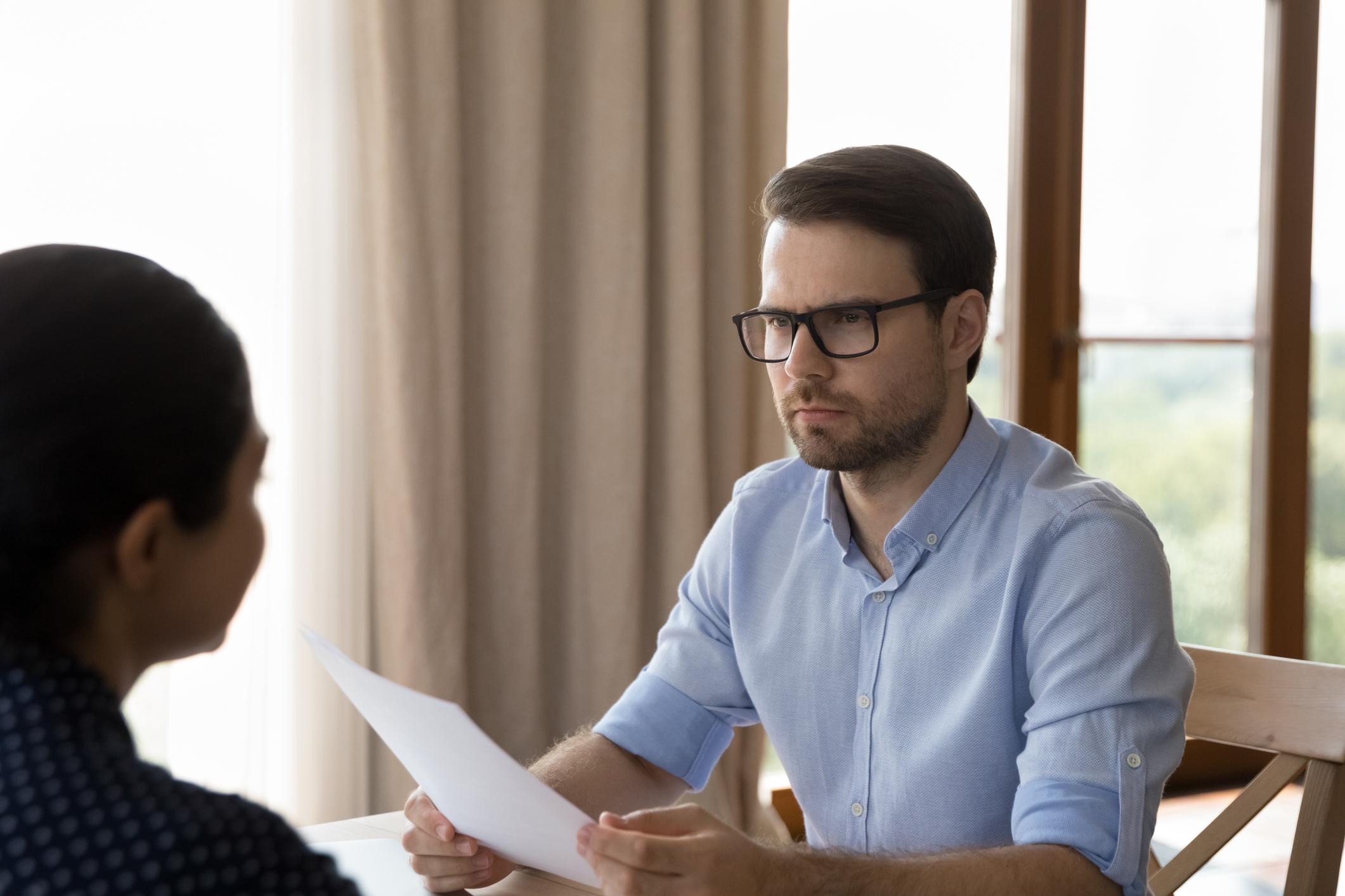 Annoyed-man-looking-at-woman-he-is-interviewing-for-work-interview-bias