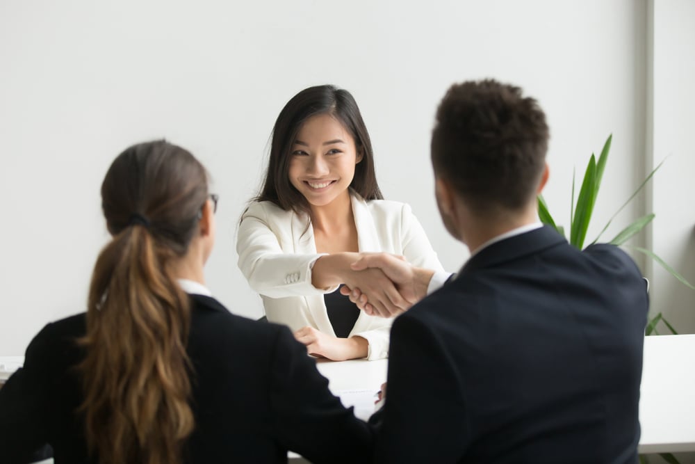 Asian-woman-being-hired-shaking-hands-with-man-linkedin-profile