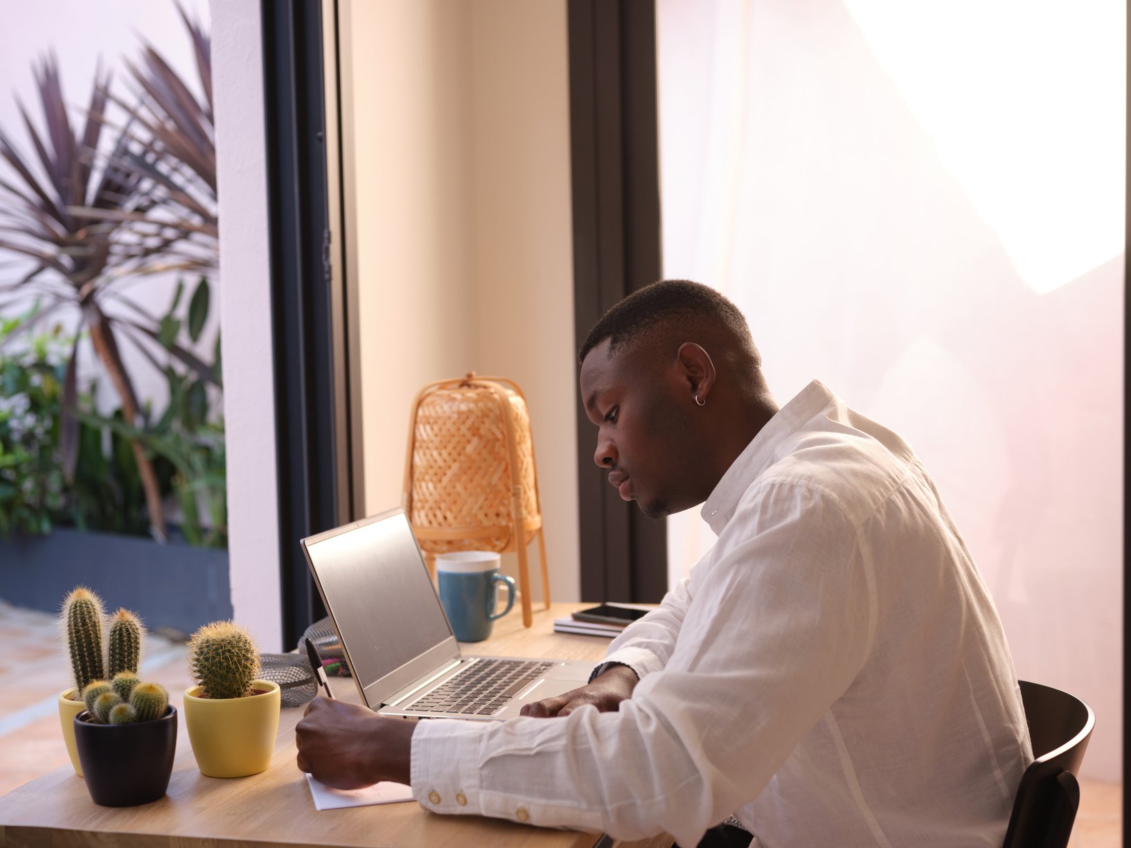 Black-Man-Writing-Notes-In-Desk