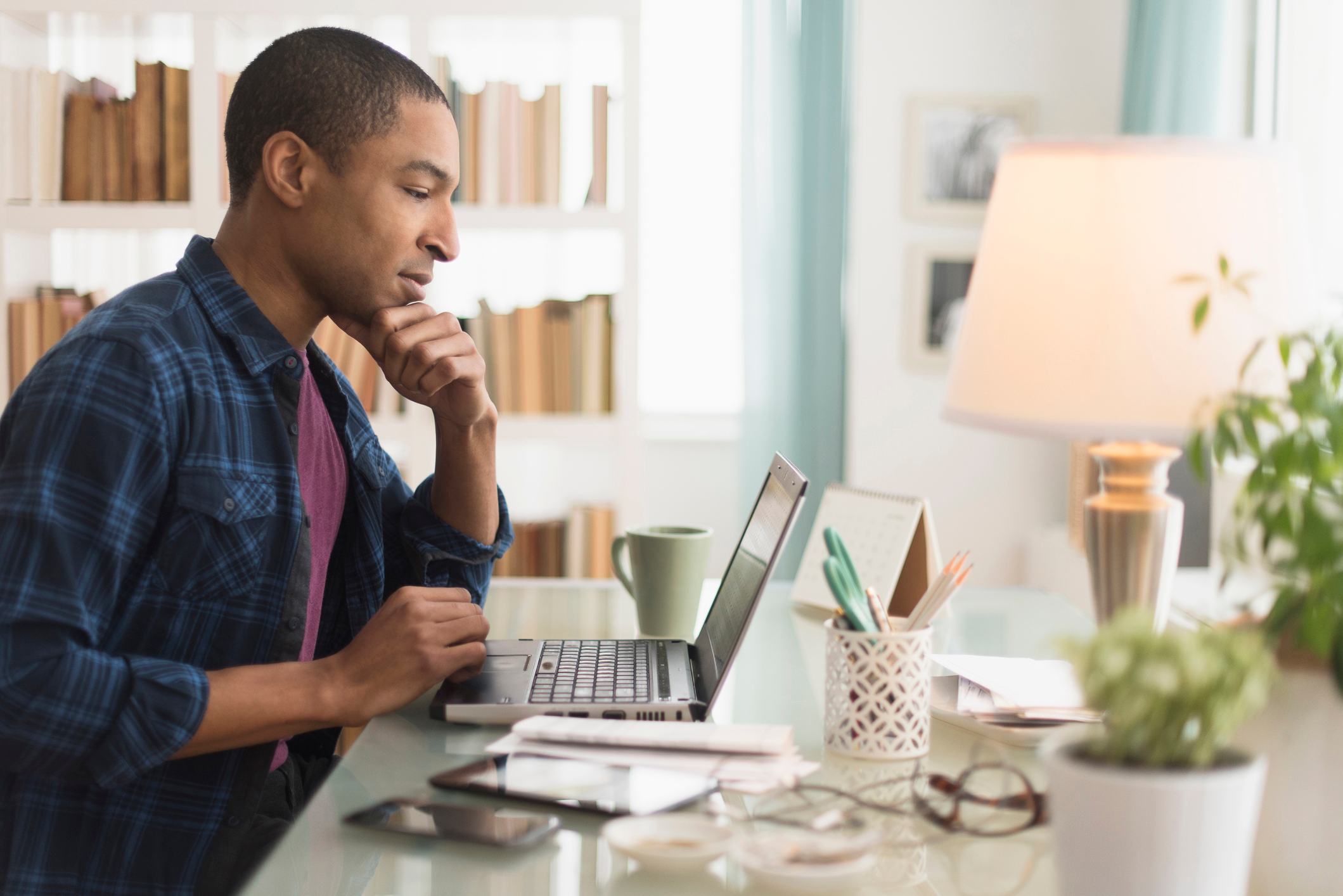 Black-businessman-working-on-laptop-at-desk-professional-references