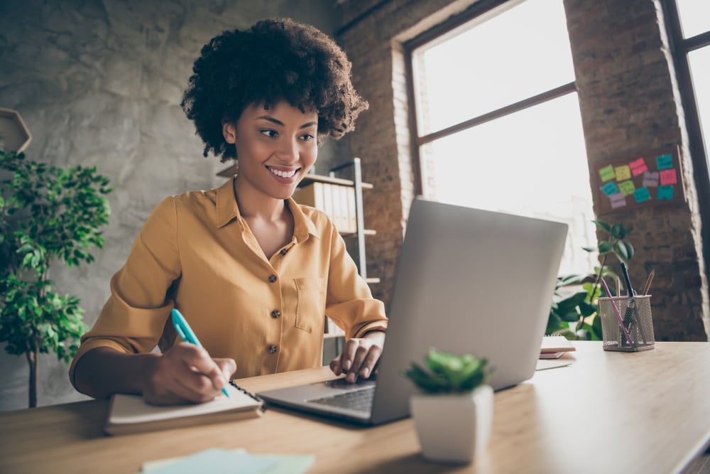 Black-woman-taking-notes-in-front-of-laptop-holiday-messages-to-employees