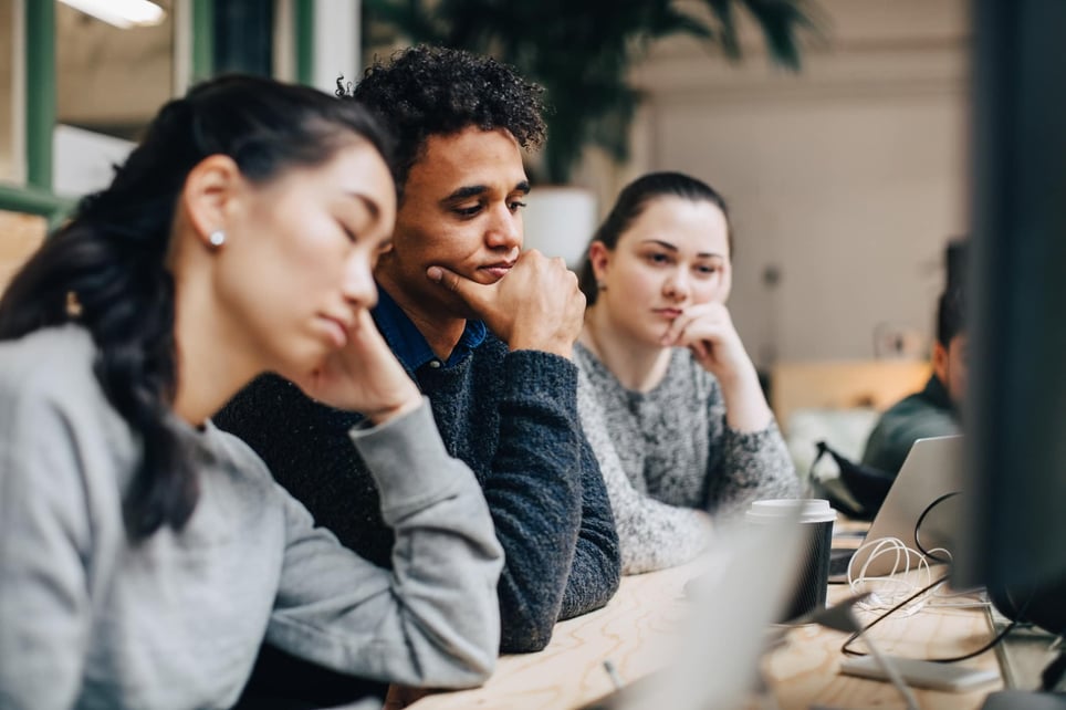 Bored-business-colleagues-sitting-at-desk-in-office-how-to-overcome-laziness