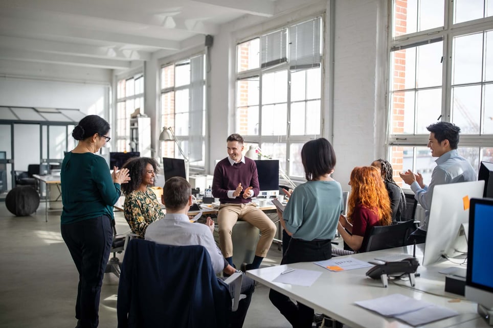 Business-team-clapping-for-a-female-colleague-quotes-to-motivate-a-team