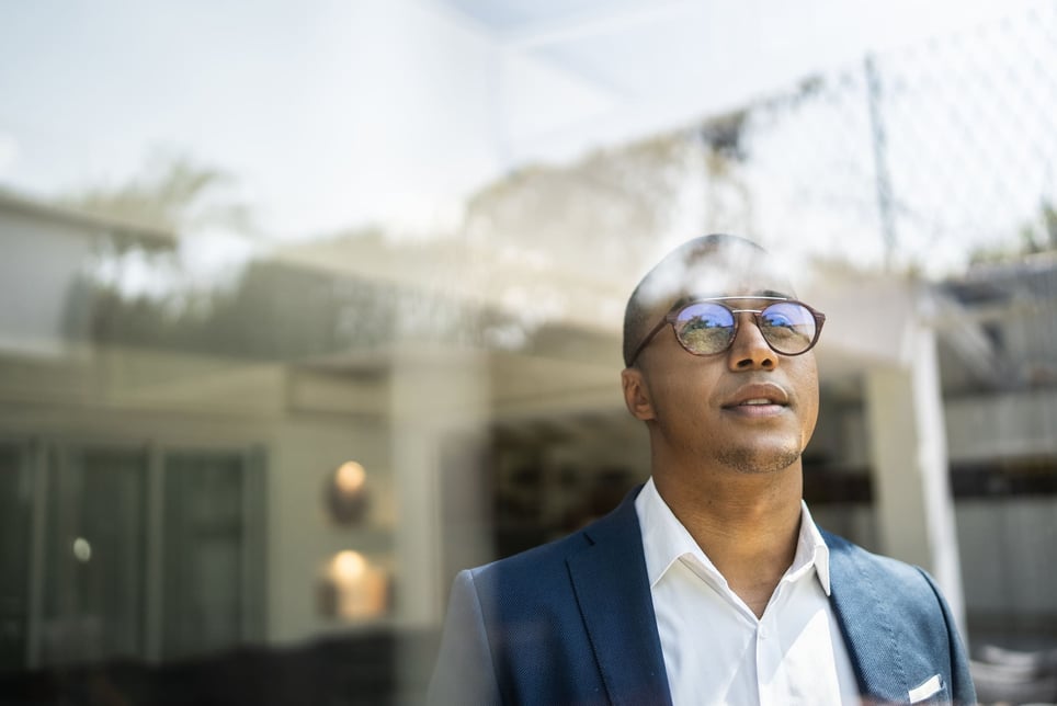 Businessman-looking-out-of-window-choosing-between-two-jobs