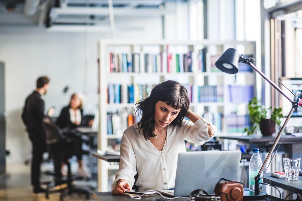 Businesswoman-looking-at-laptop-while-sitting-in-office-how-to-deal-with-career-disappointment