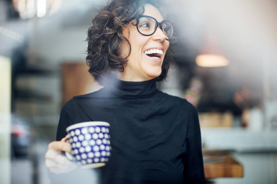 Cheerful-businesswoman-at-coffee-shop-happy-life-vs-meaningful-life