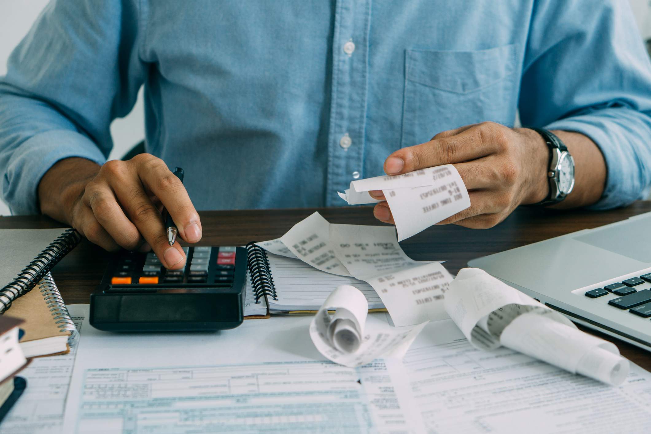 Close-up-of-mans-hands-using-calculator-what-to-do-when-you-get-laid-off