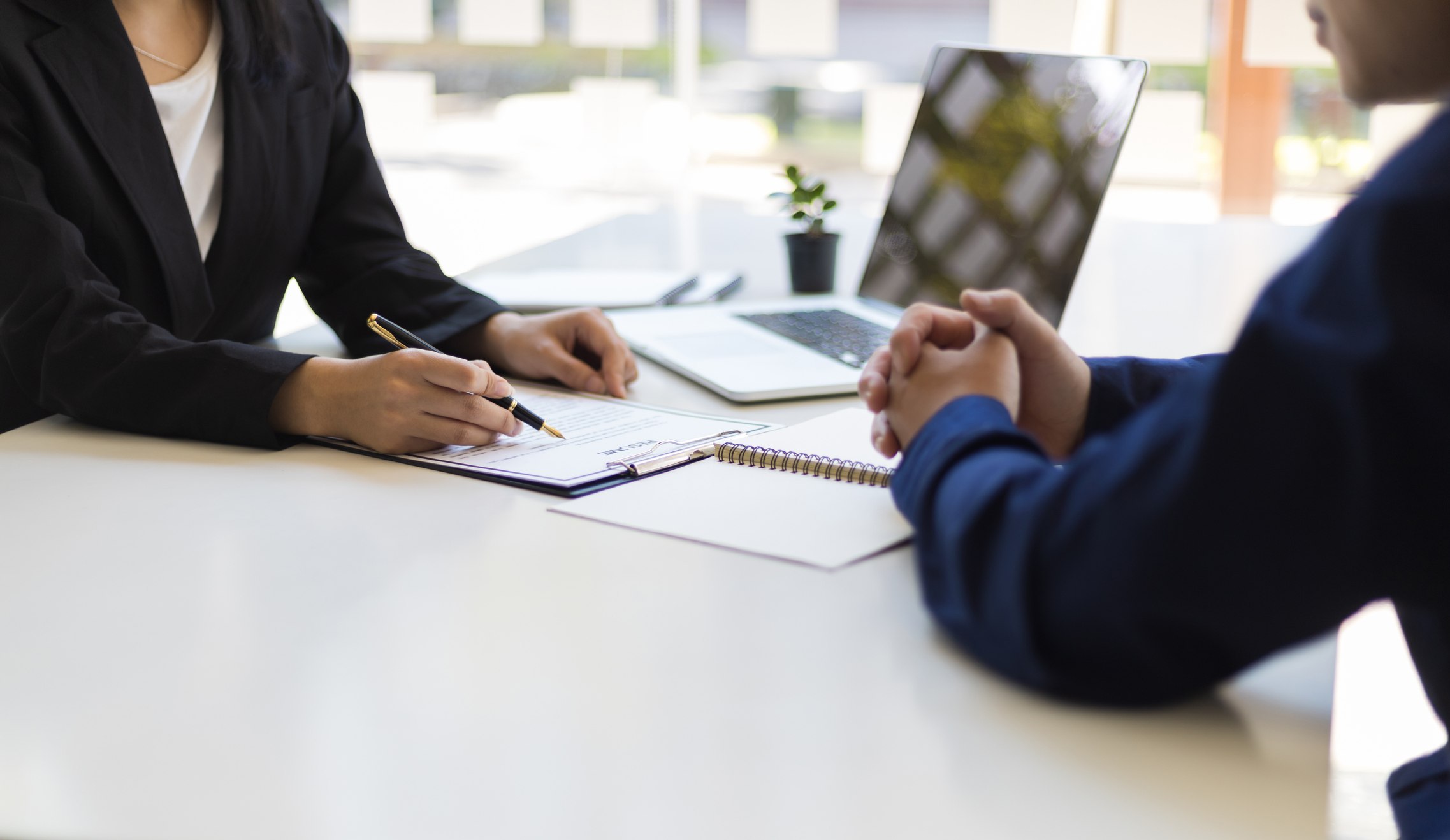 Close-up-of-two-peoples-hands-reviewing-document-at-work-interview-part-time-employee-benefits