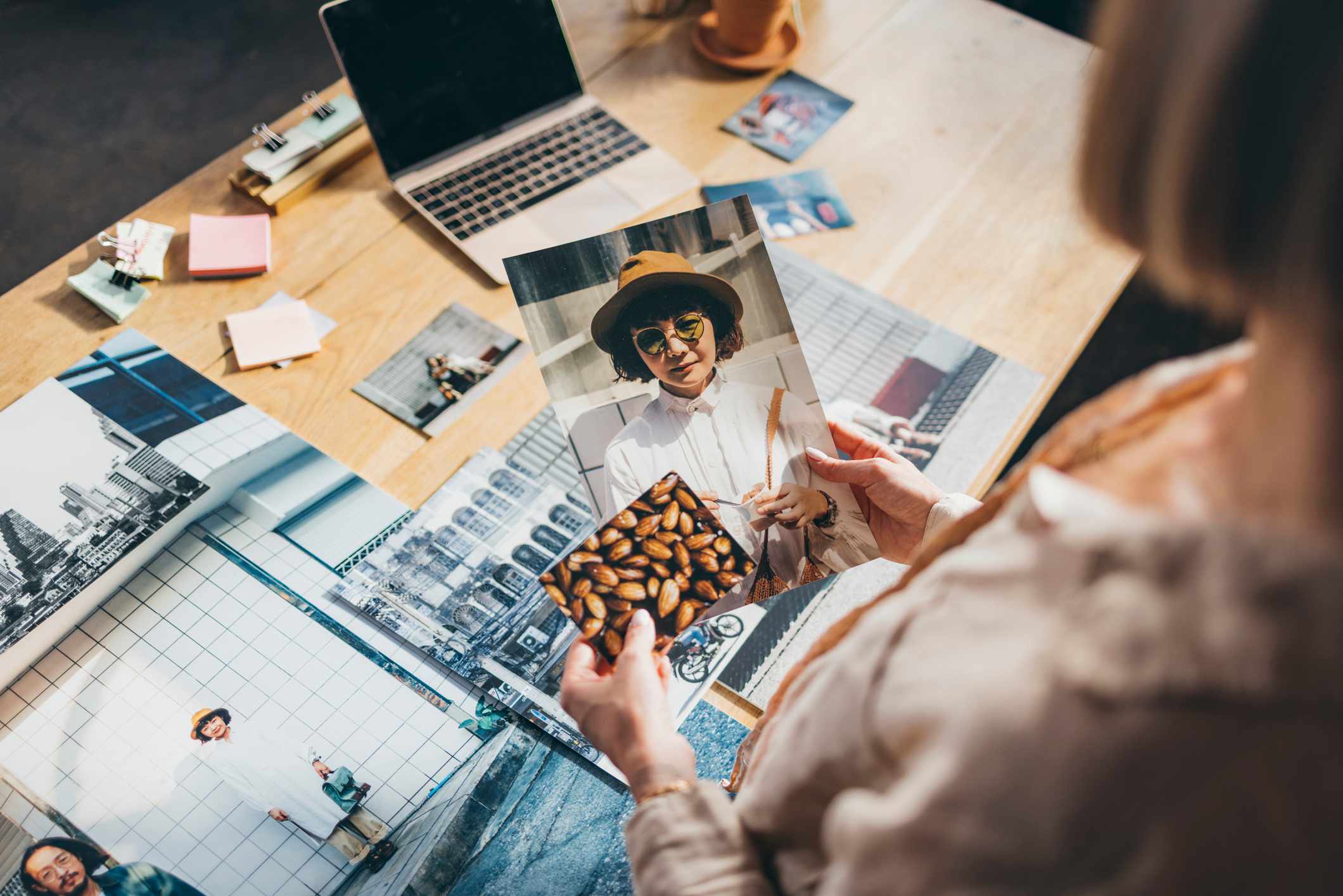 Close-up-of-womans-hands-holding-printed-pictures-for-magazine-journalism-degree-jobs