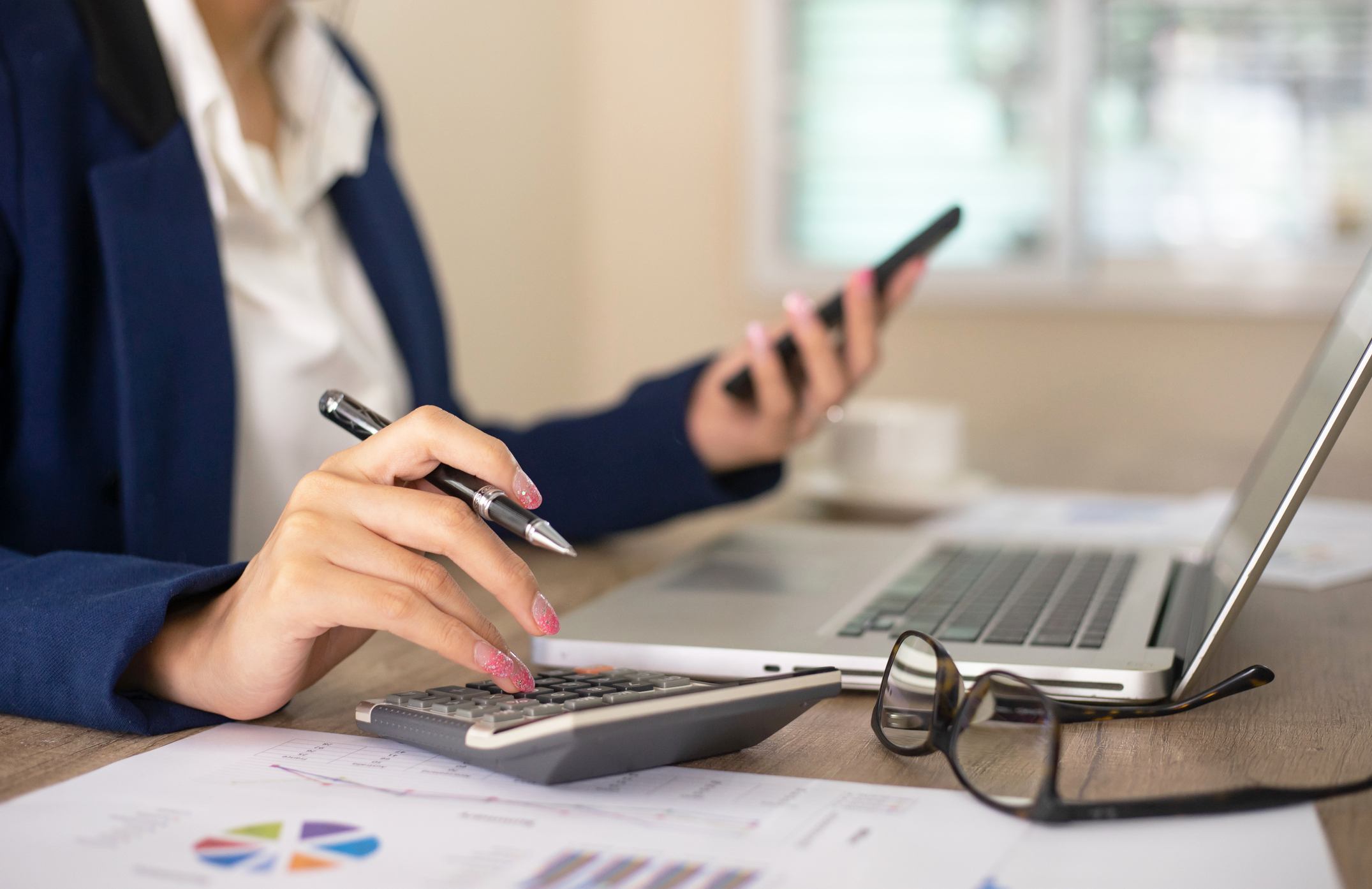 Close-up-of-womans-hands-using-calculator-employee-owned-companies