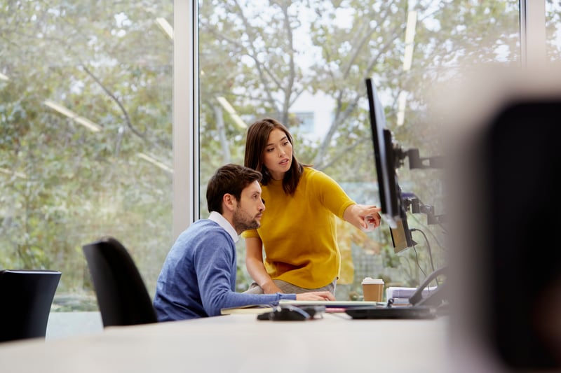 Colleagues-Discussing-Over-Computer-how-to-make-people-like-you