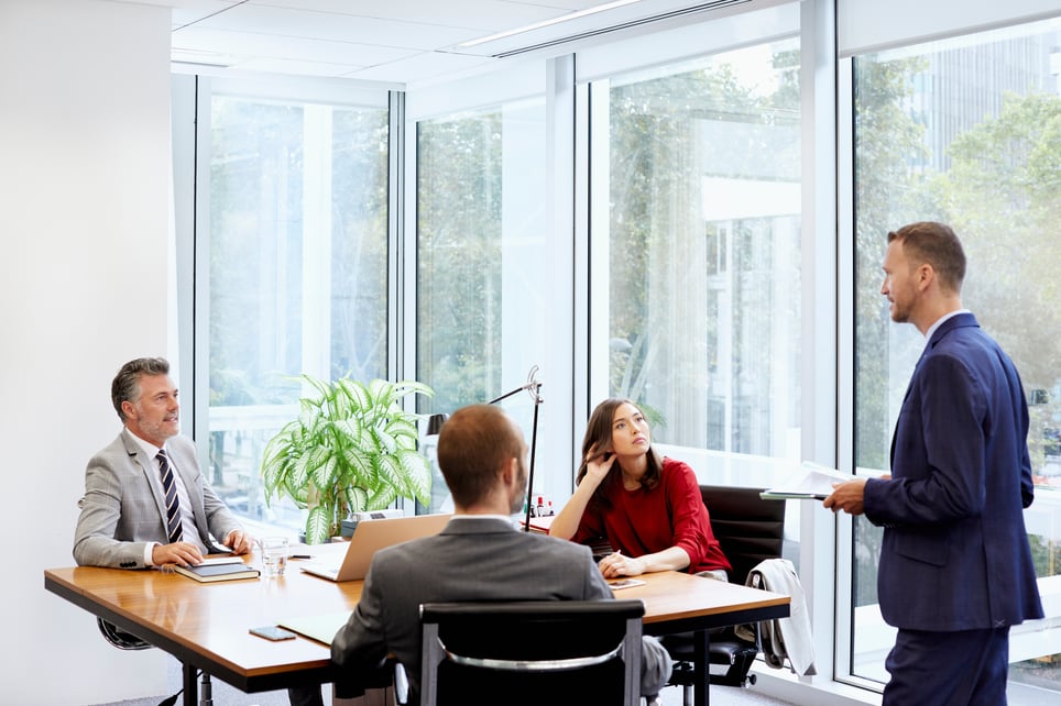 Colleagues-Looking-At-Businessman-With-Documents-decision-making-process-in-management