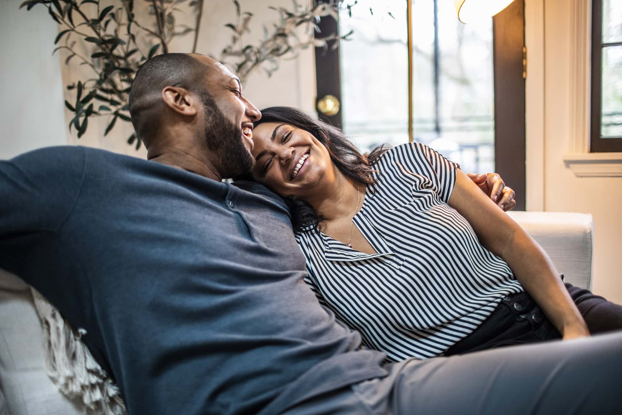 Couple-lounging-happily-on-couch-work-from-home-policy