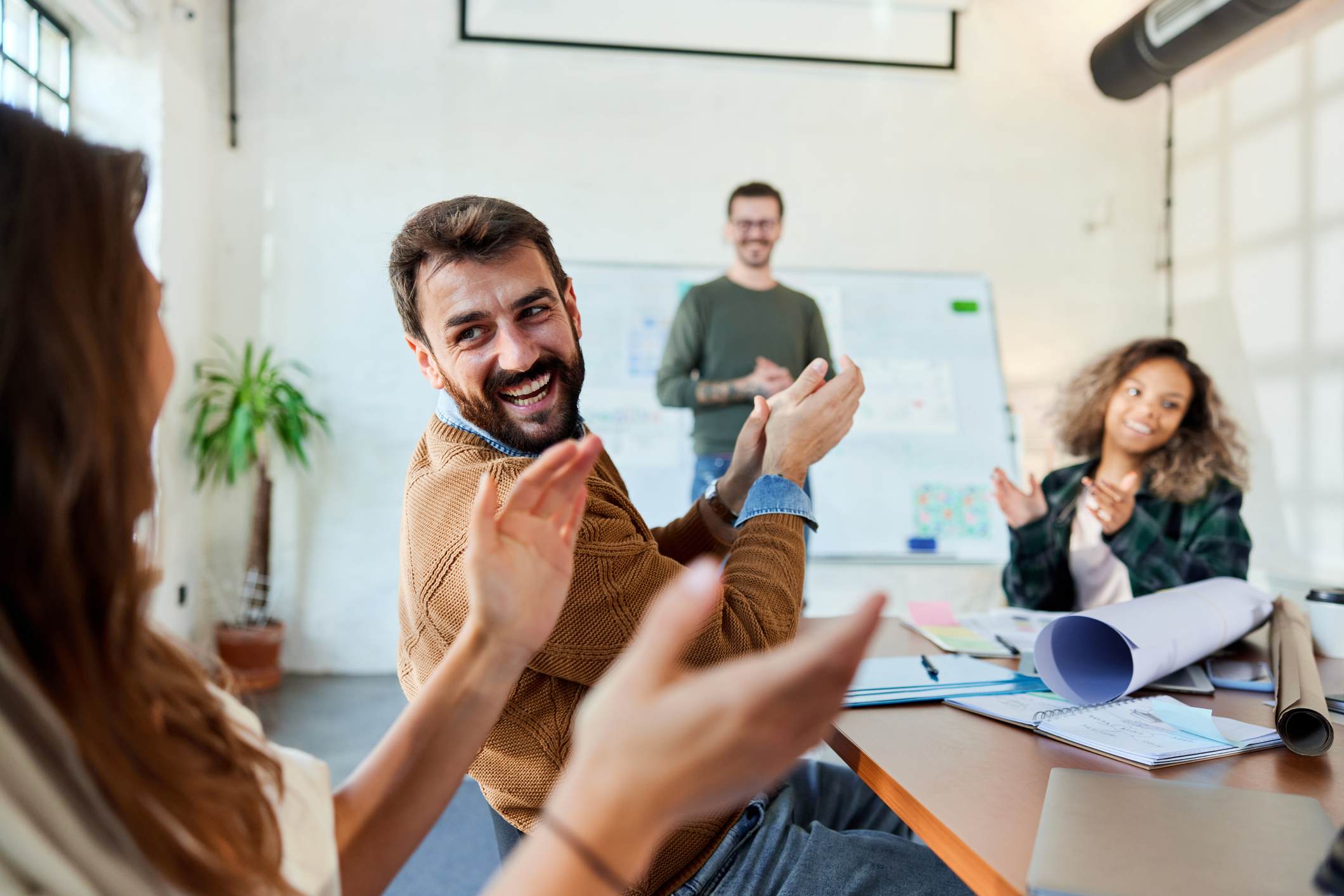 Coworkers-at-meeting-cheering-each-other-promotion-announcement