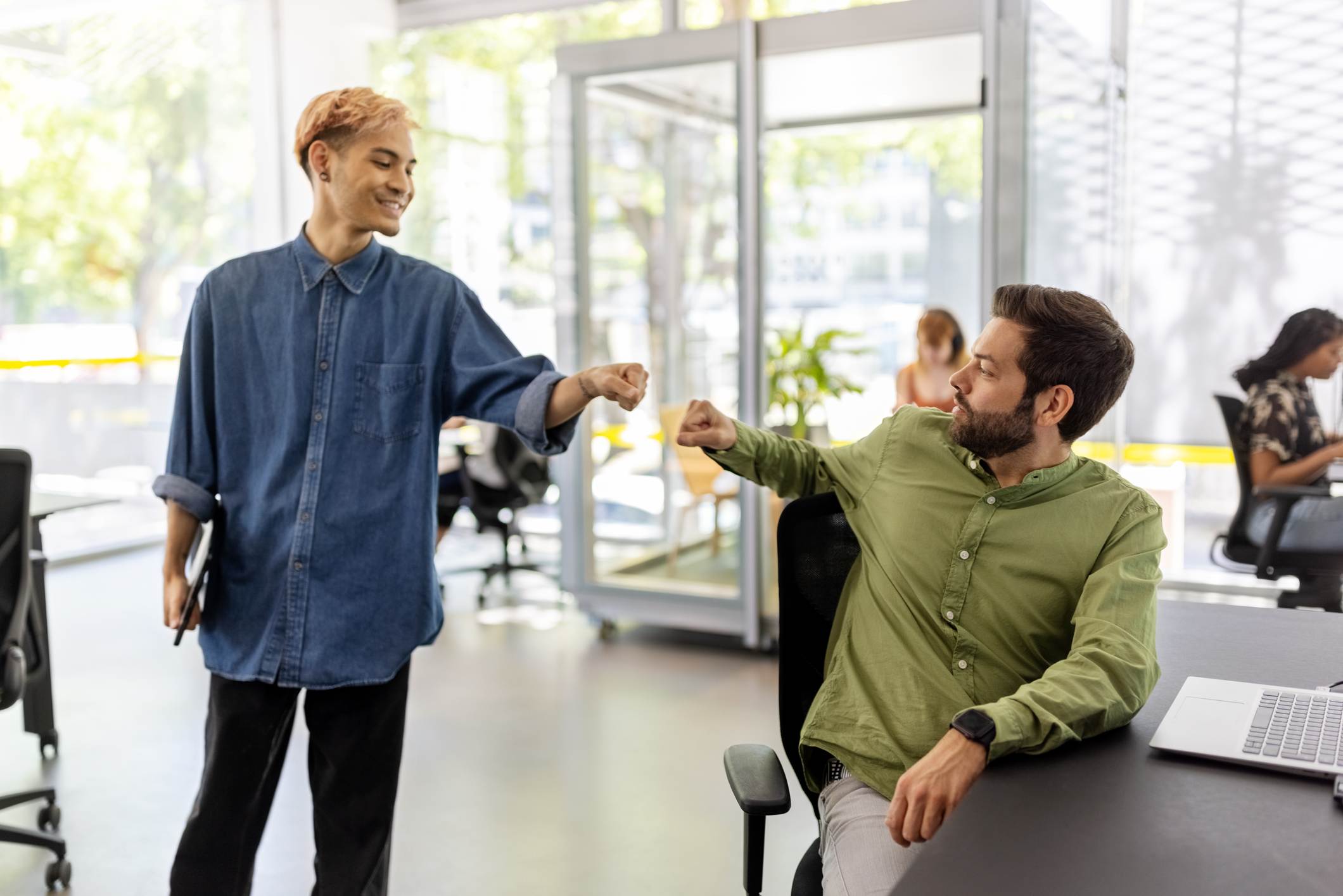 Coworkers-giving-each-other-high-five-at-office-promotion-announcement