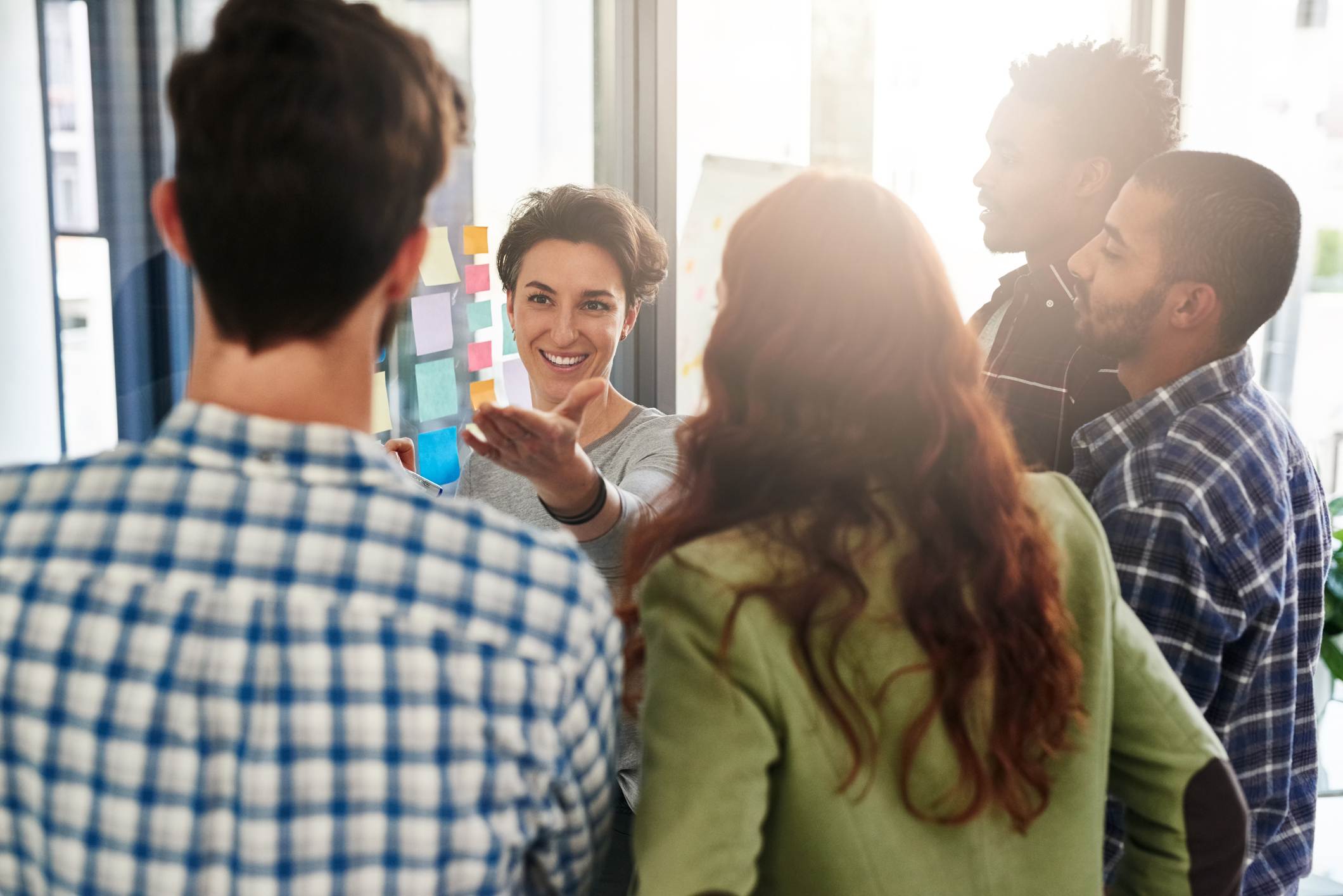 Coworkers-listening-to-woman-giving-ideas-how-to-stop-micromanaging