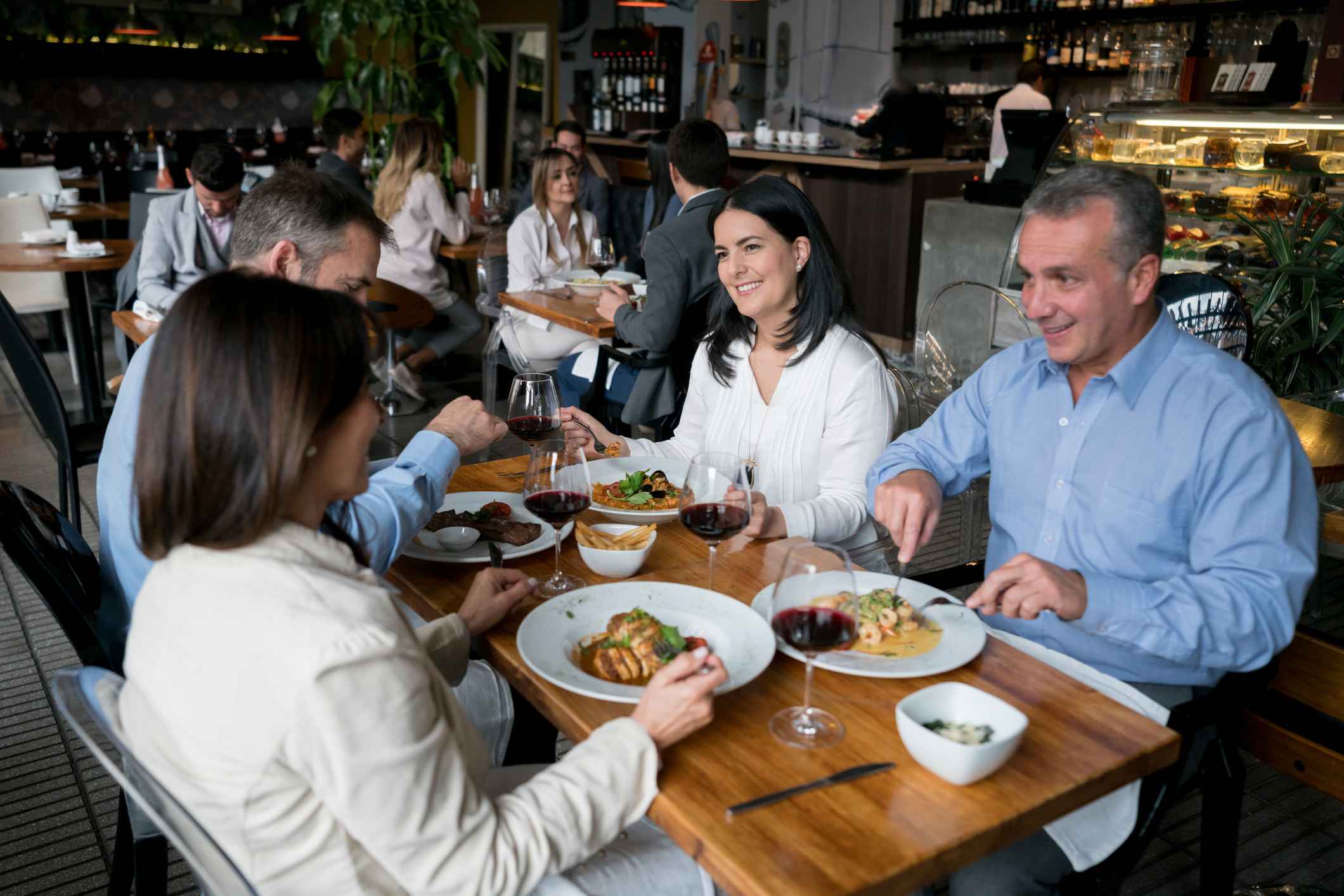 Cowrkers-smiling-and-talking-at-lunch-in-a-restaurant-how-to-congratulate-someone-on-a-promotion