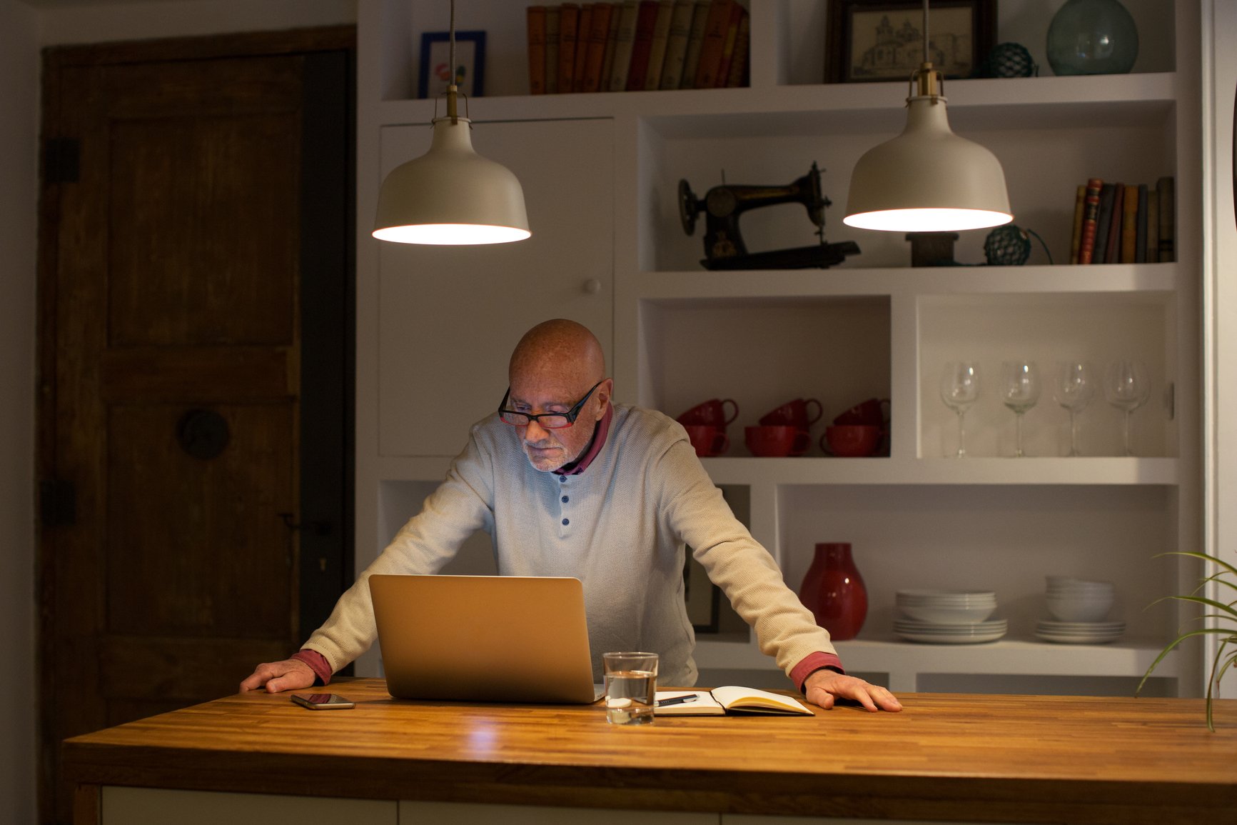 Elderly-Man-Working-At-Home-Office-Late-overqualified-for-job