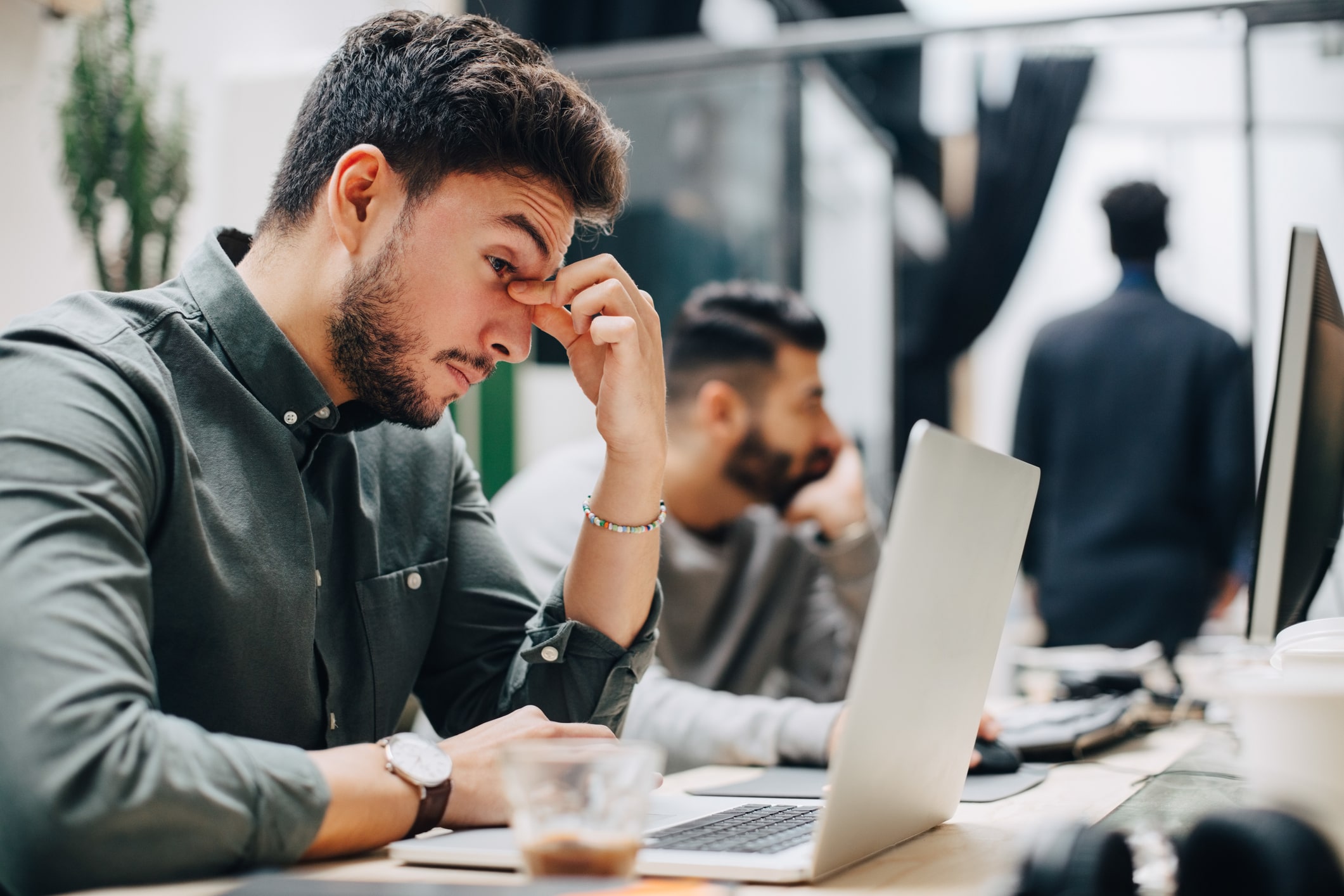 Exhausted-businessman-looking-at-laptop-on-desk-what-are-stressors