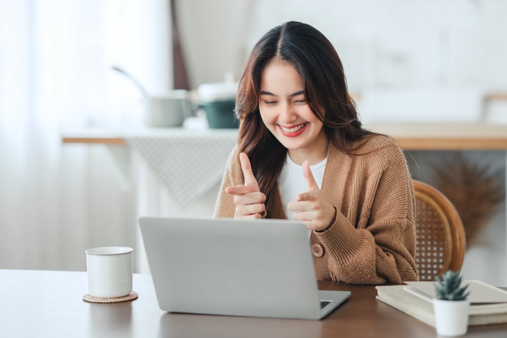 Female-pointing-at-laptop-smiling-linkedin-profile