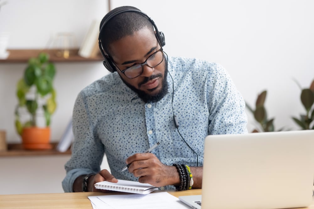 Focused-african-business-man-in-headphones-bored-at-work