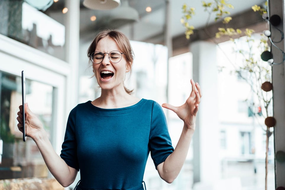 Frustrated-businesswoman-screaming-while-holding-digital-tablet-in-cafe-purpose-of-anger-emotion