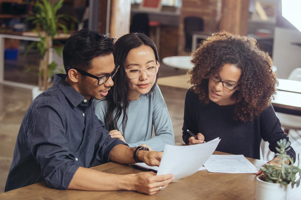 Group-of-coworkers-going-over-paperwork-together-compensation-plan