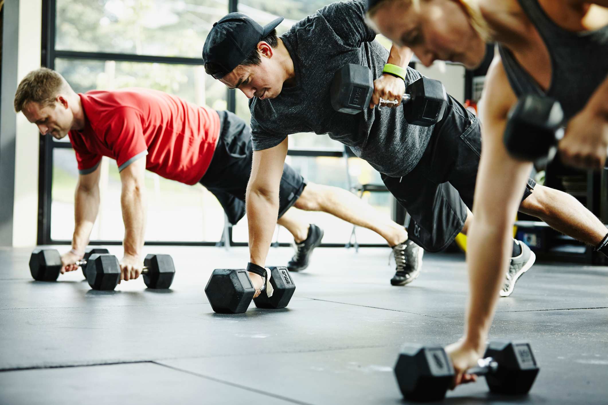 Group-of-friends-doing-pushups-with-dumbbells-in-gym-characteristics-of-a-determined-person