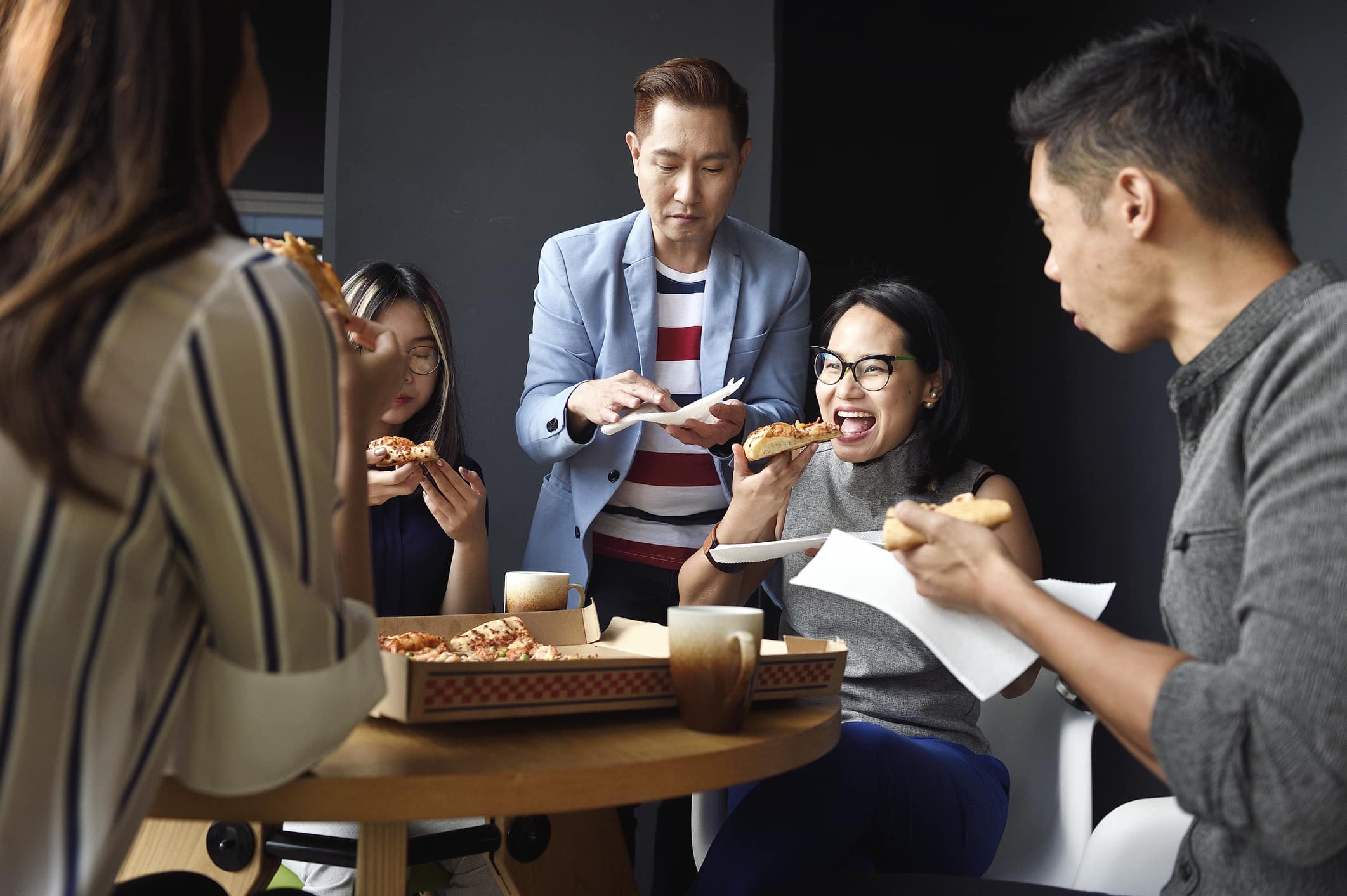 Group-of-happy-coworkers-celebrating-with-pizza-effects-of-peer-pressure