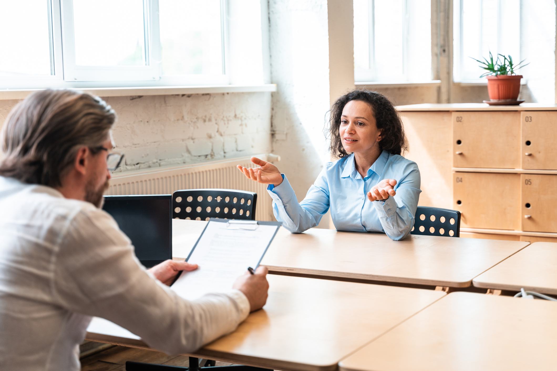 Happy-Young-Woman-Sitting-On-Table-why-are-you-leaving-your-current-job