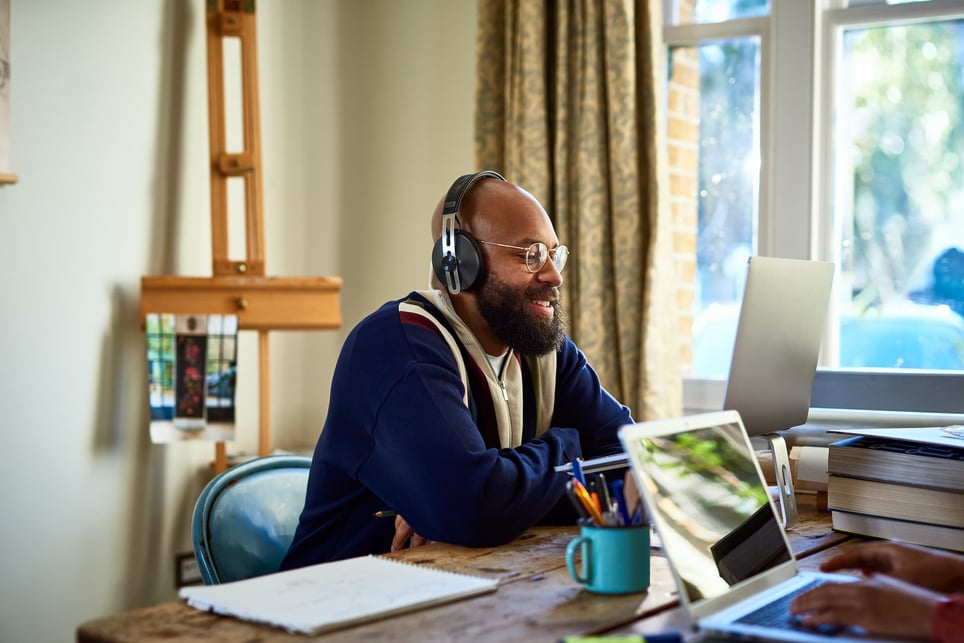 Happy-man-working-from-home-next-to-someone-slightly-off-camera-how-to-get-a-remote-job