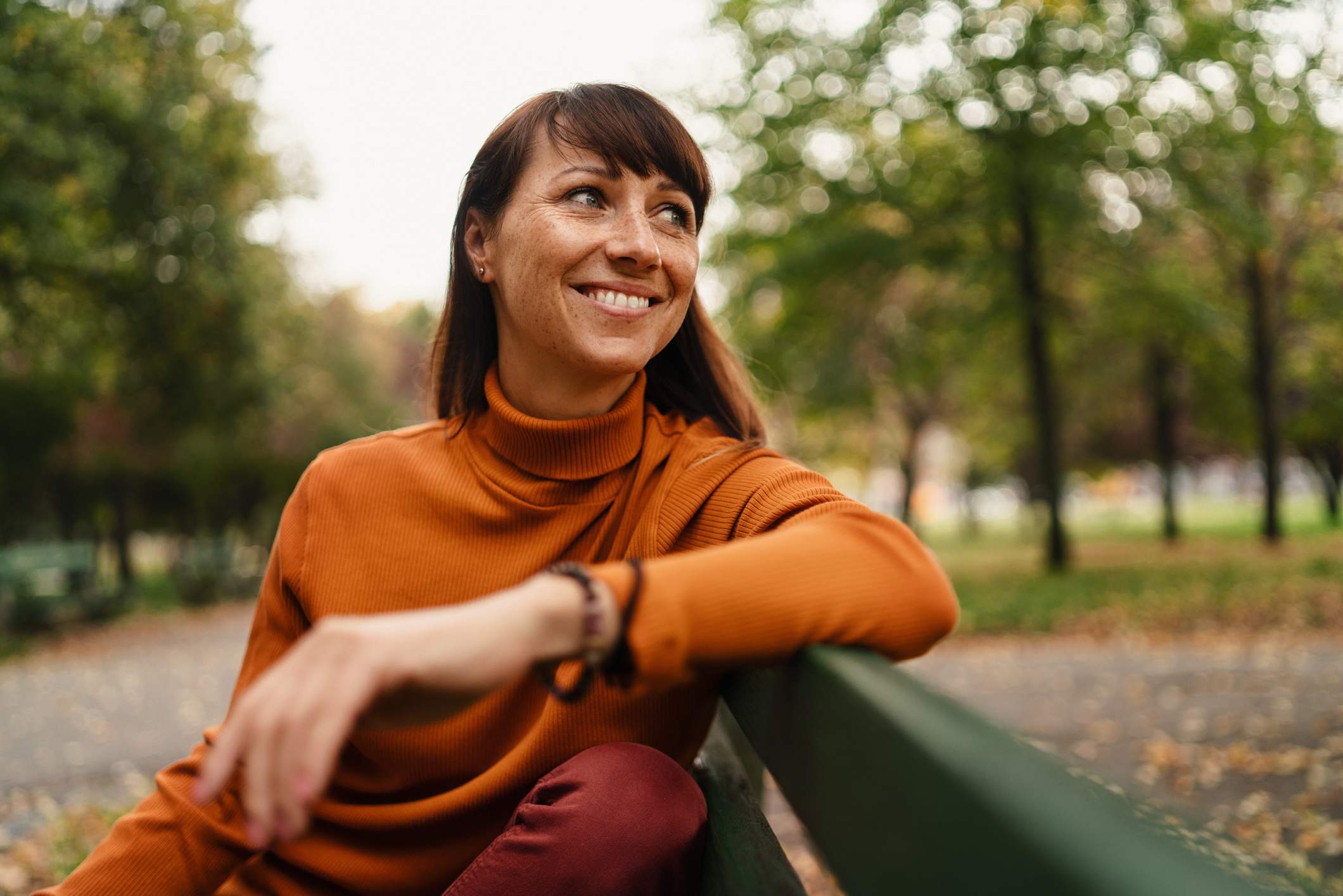 Happy-woman-by-herself-in-a-park-bench-affirmations-for-imposter-syndrome