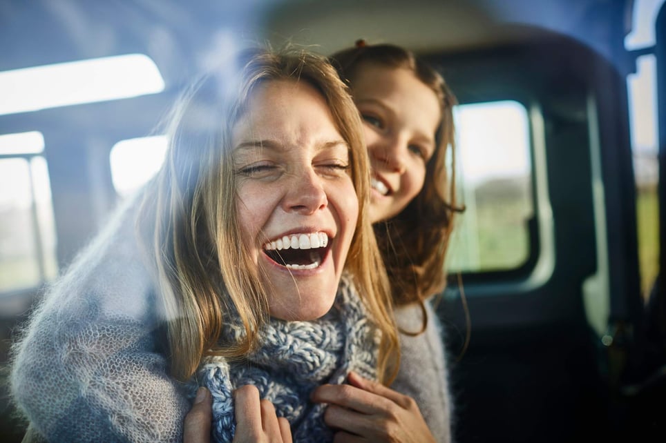 Happy-woman-laughing-with-closed-eyes-getting-hugged-by-loved-one-how-to-release-endorphins