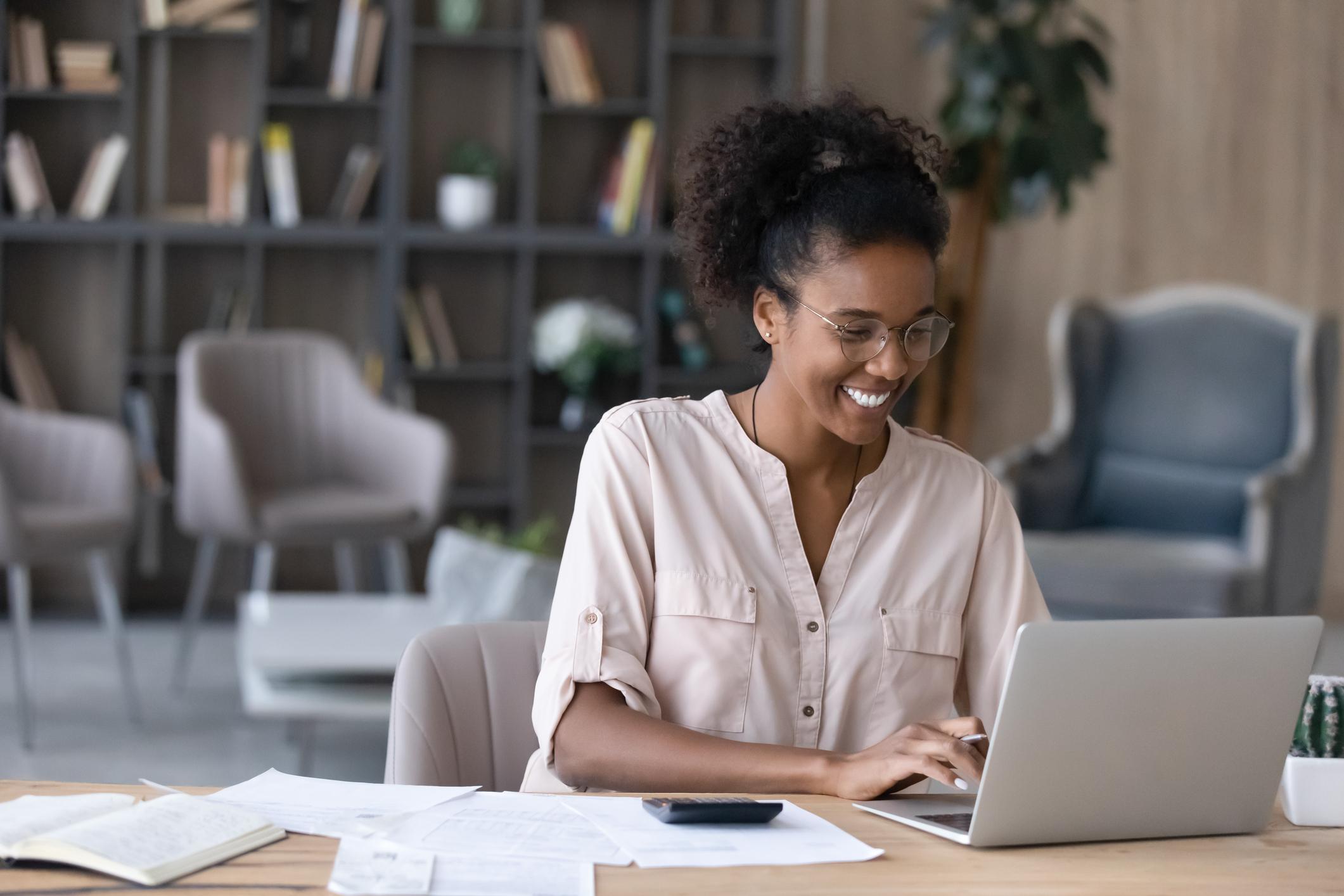 Happy-woman-writing-on-laptop-how-to-end-an-email