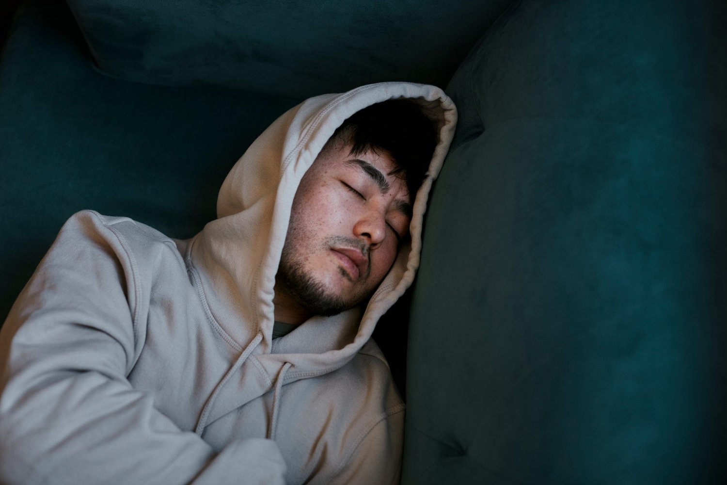 High-angle-view-of-man-sleeping-on-sofa-how-to-sleep-earlier