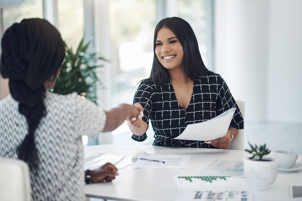 Hiring-manager-smiling-and-giving-handshake-to-woman-hiring-manager-vs-recruiter