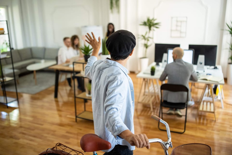 Japanese-businessman-pushing-bicycle-and-leaving-workplace-after-work-goodbye-email-to-coworkers