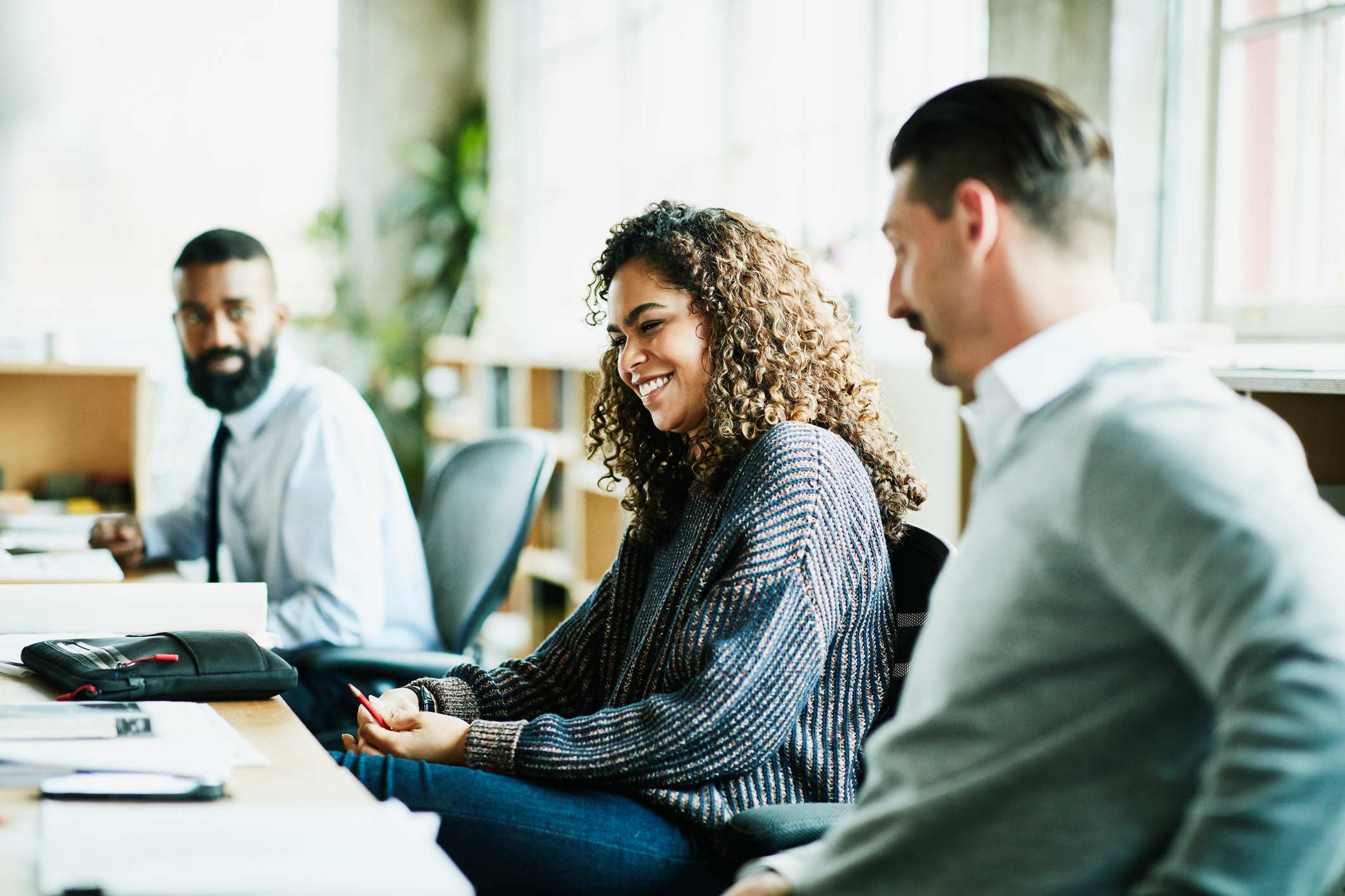 Laughing-coworkers-in-discussion-at-workstation-good-reason-to-leave-work