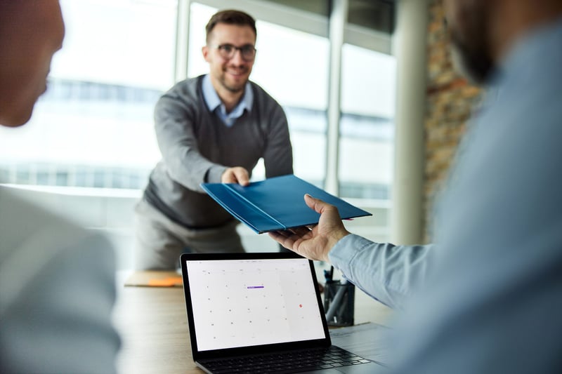 Male-candidate-giving-his-paperwork-to-human-resource-team-on-a-job-interview-in-the-office-what-is-job-crafting-and-why-does-it-matter