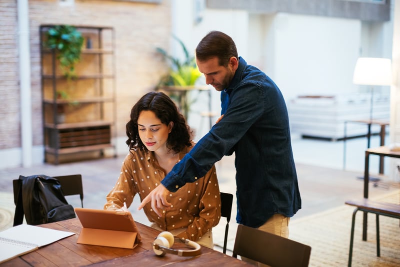 Male-coach-helping-woman-with-project