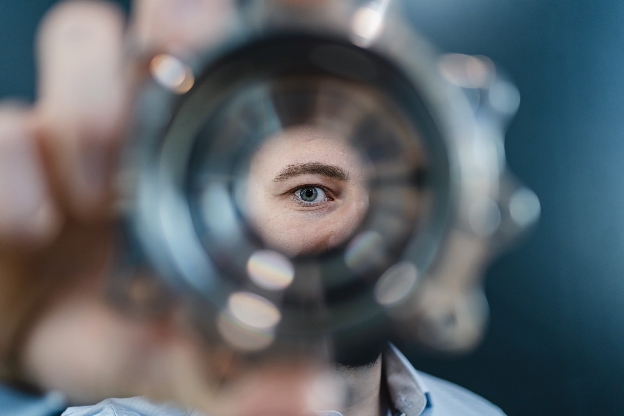 Male-professionals-eyes-seen-through-circular-machine-part-in-factory-monthly-goals-examples