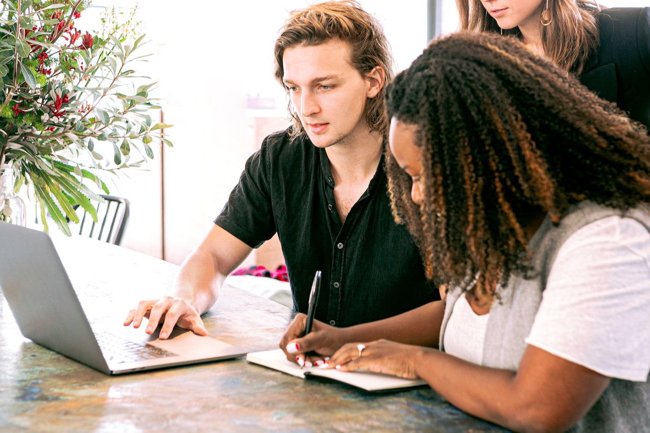 Man-Working-on-Laptop-while-Woman-Takes-Notes-how-to-prepare-for-a-new-job