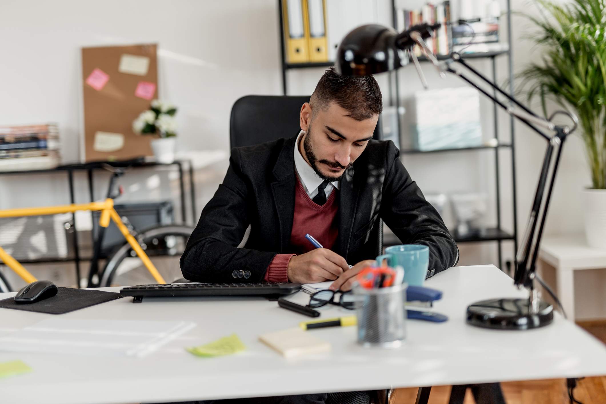 Man-at-his-office-writing-down-on-paper-negative-feedback-to-manager-examples