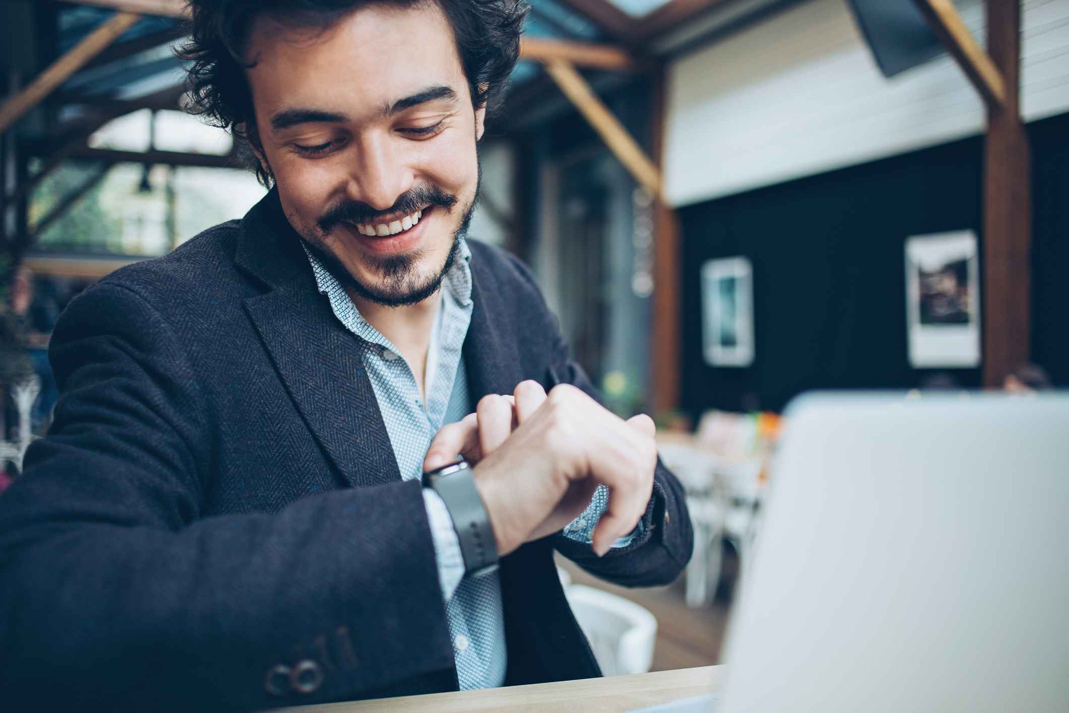 Man-checking-his-smart-watch-at-interview-signs-of-good-interview