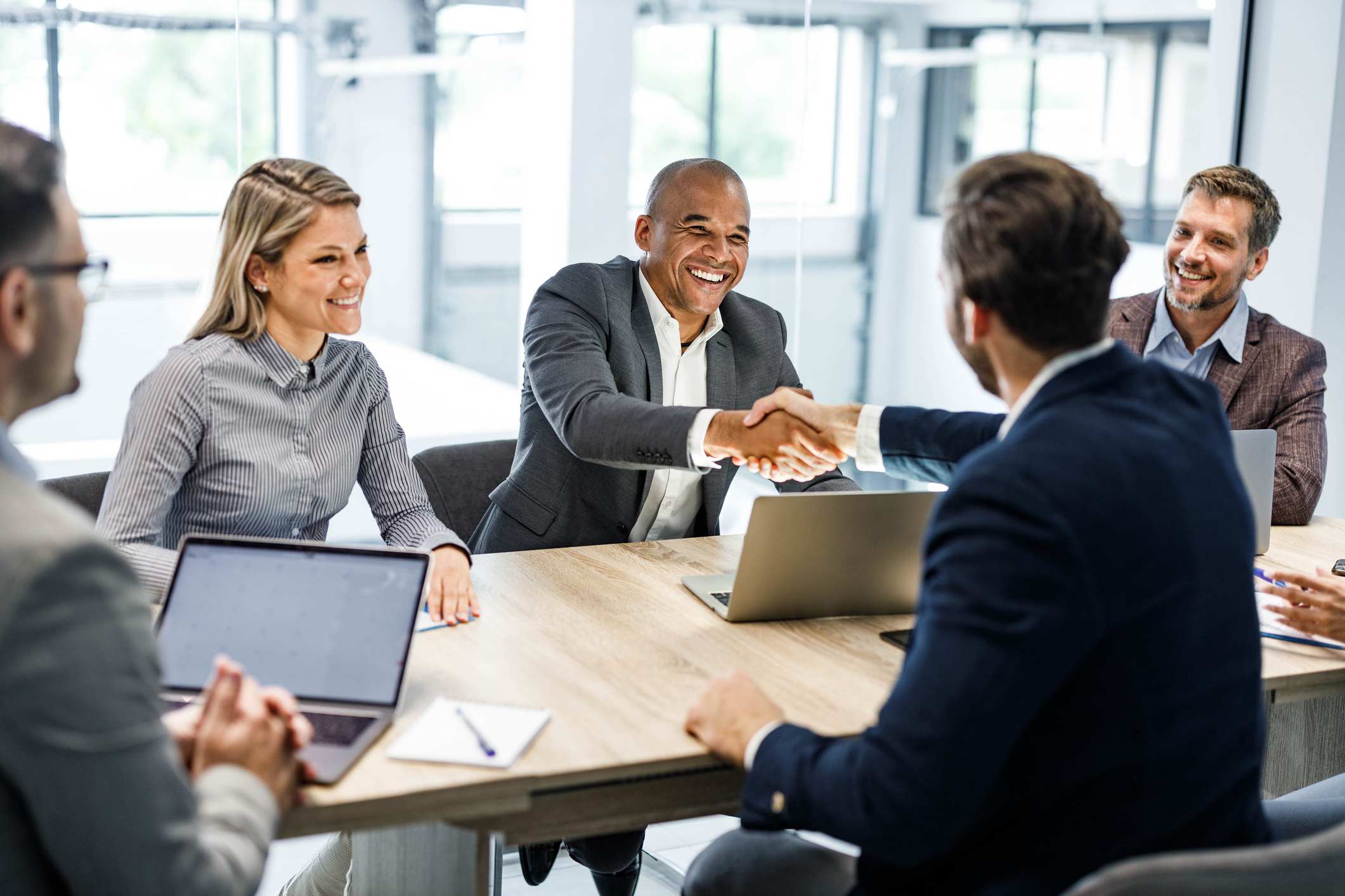 Man-giving-handshake-to-coworker-who-got-promotion-how-to-congratulate-someone-on-a-promotion