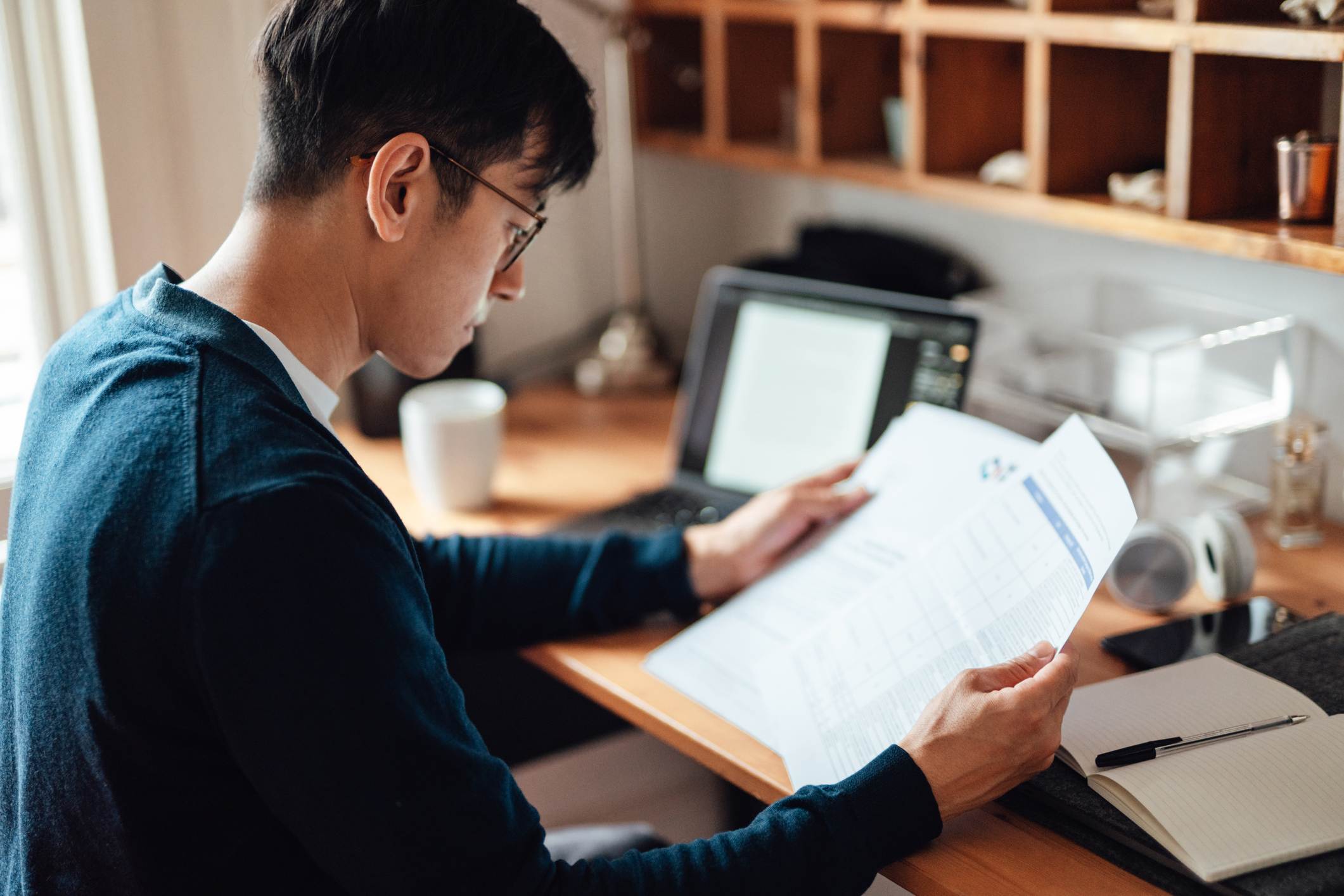 Man-looking-at-two-resumes-at-the-same-time-at-office-how-far-back-should-a-resume-go