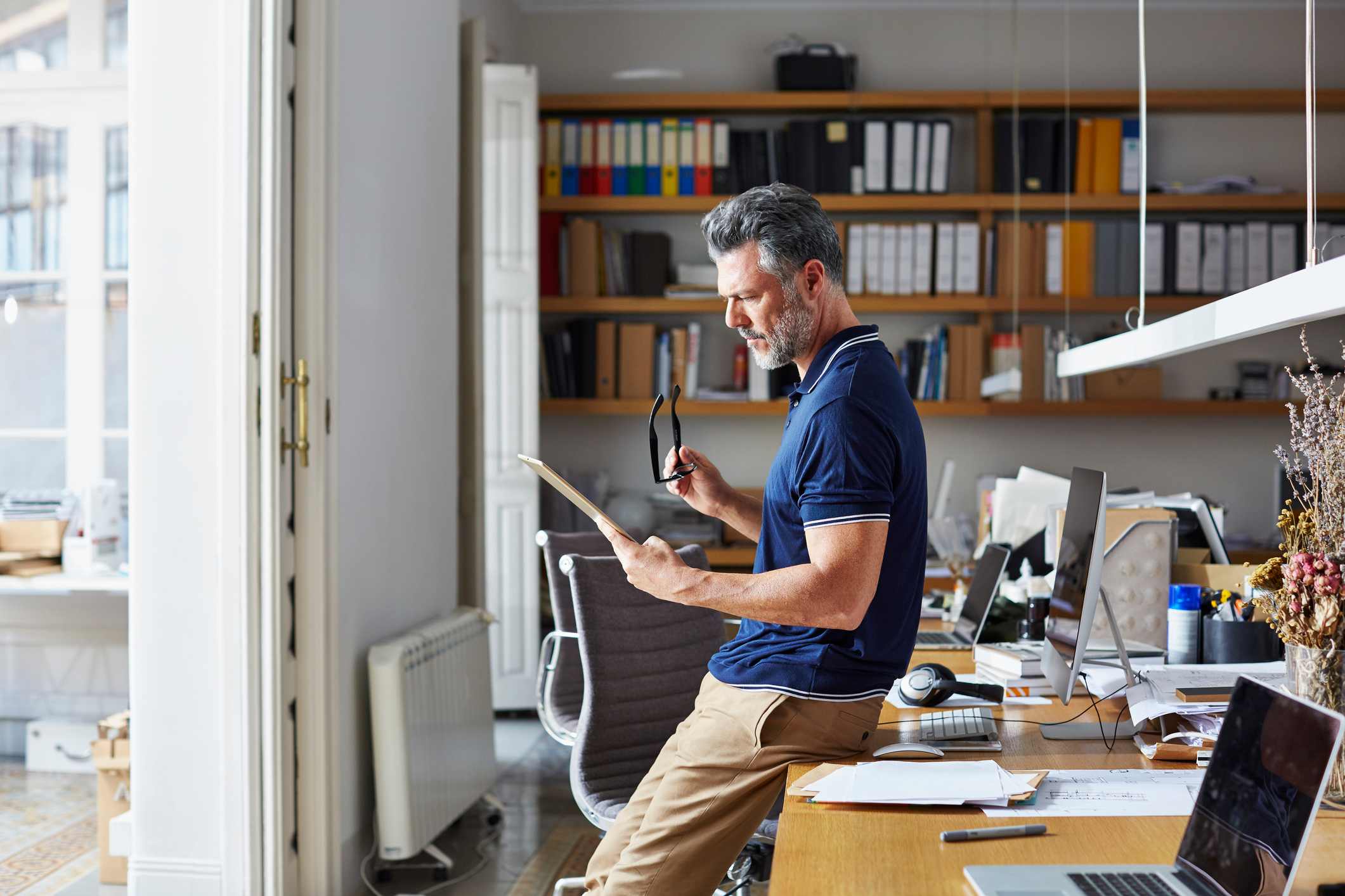 Man-reading-something-from-his-iPad-at-home-office-what-to-do-when-you-get-laid-off